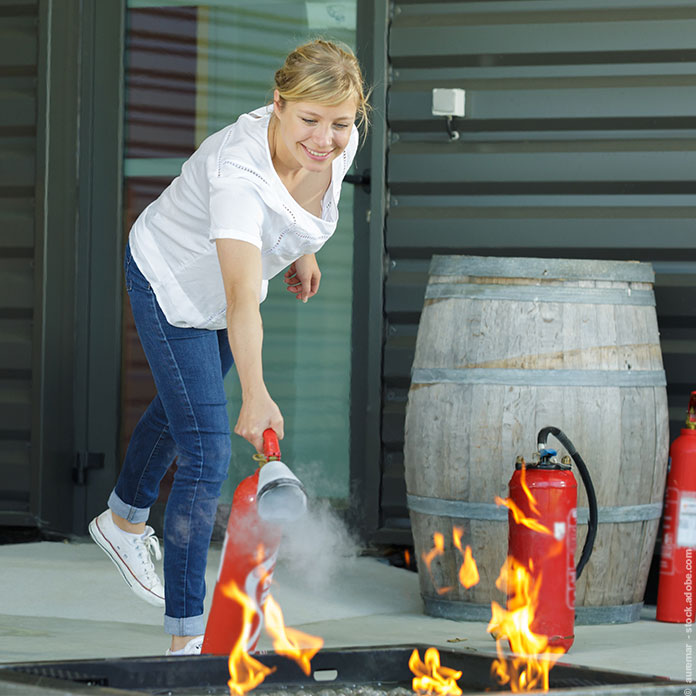 Eine Frau lernt den Umgang mit einem Feuerlöscher