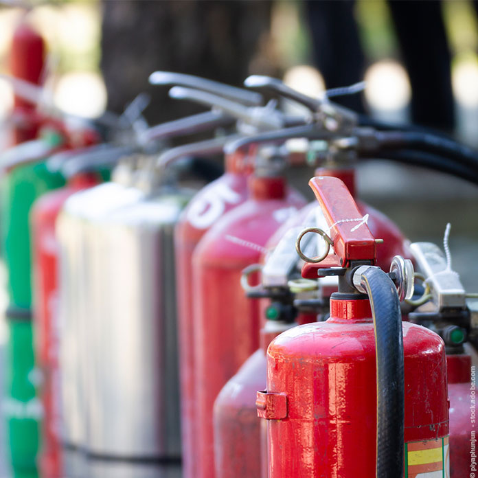 Nahaufnahme Brandschutz-Set Verschiedene Arten von Feuerlöschern, die im Freien für Mitarbeiterschulungen aufgestellt sind.
